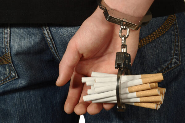 Persoon zit vast geketend aan sigaretten en verbergt dit.