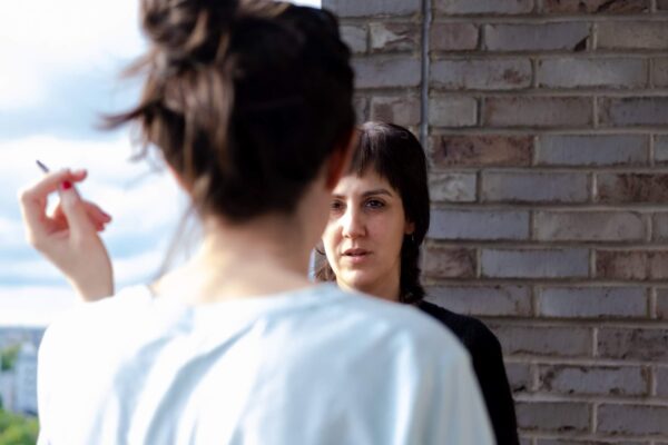 Twee vrouwen roken op het balkon