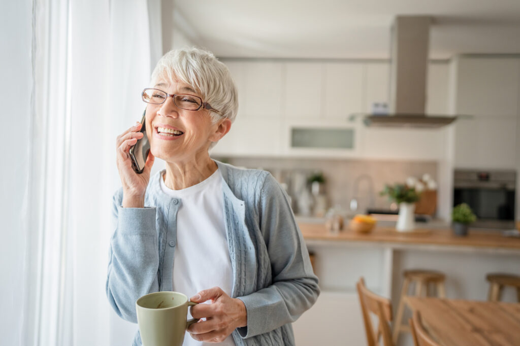 Oude vrouw die een leuke conversatie aan de telefoon heeft