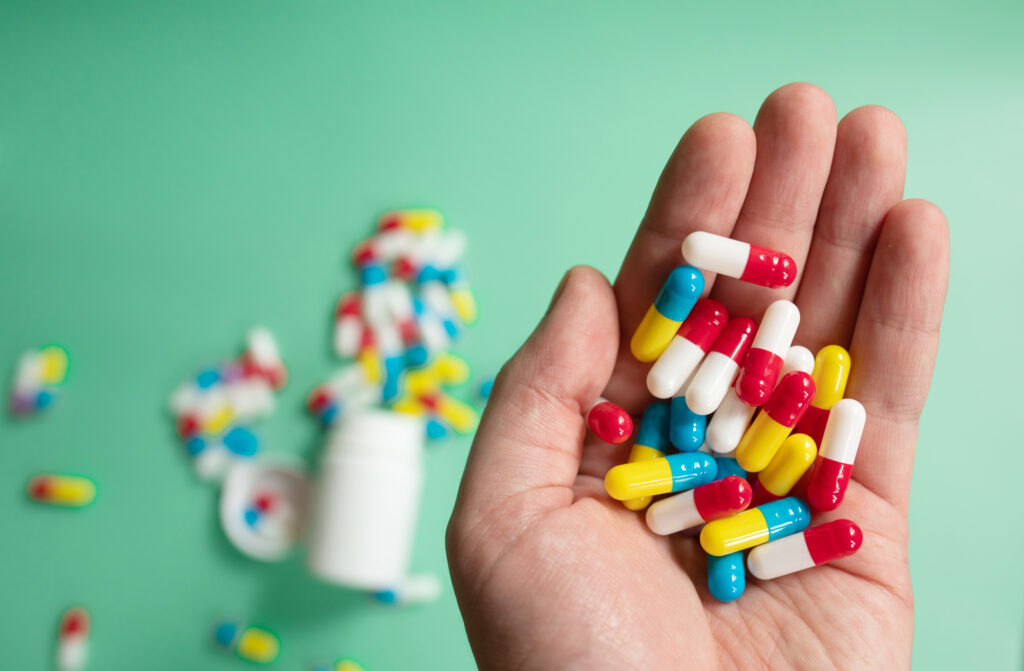 Verschillende medicijnen in een hand.