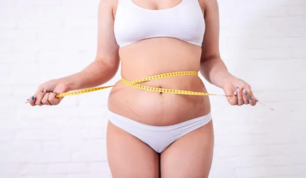 vrouw die is aangekomen door het stoppen met roken en haar buik meet