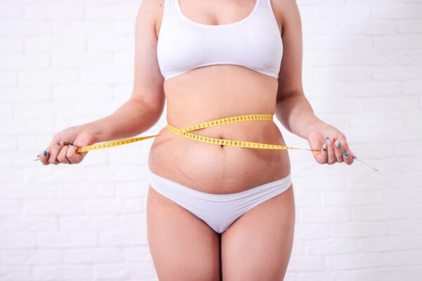 vrouw die is aangekomen door het stoppen met roken en haar buik meet