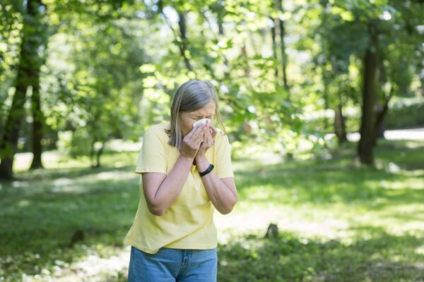 Vrouw niest door hooikoortsklachten die verergerd worden door roken